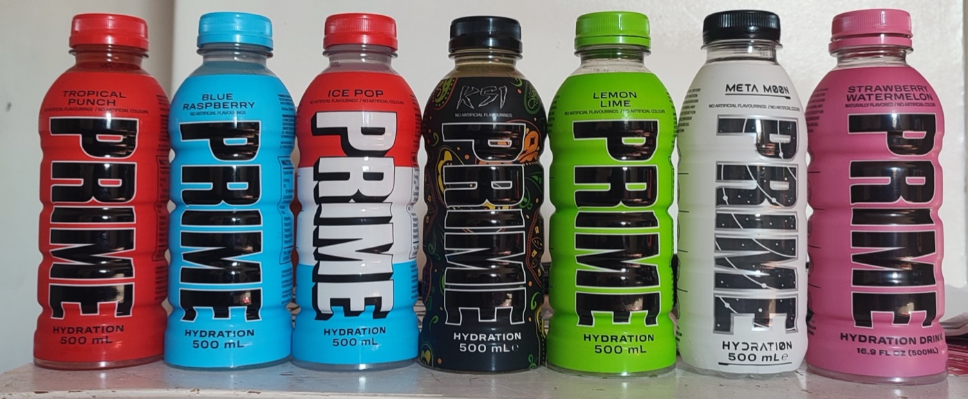Seven bottles of Prime Hydration in different flavours lined up on a shelf